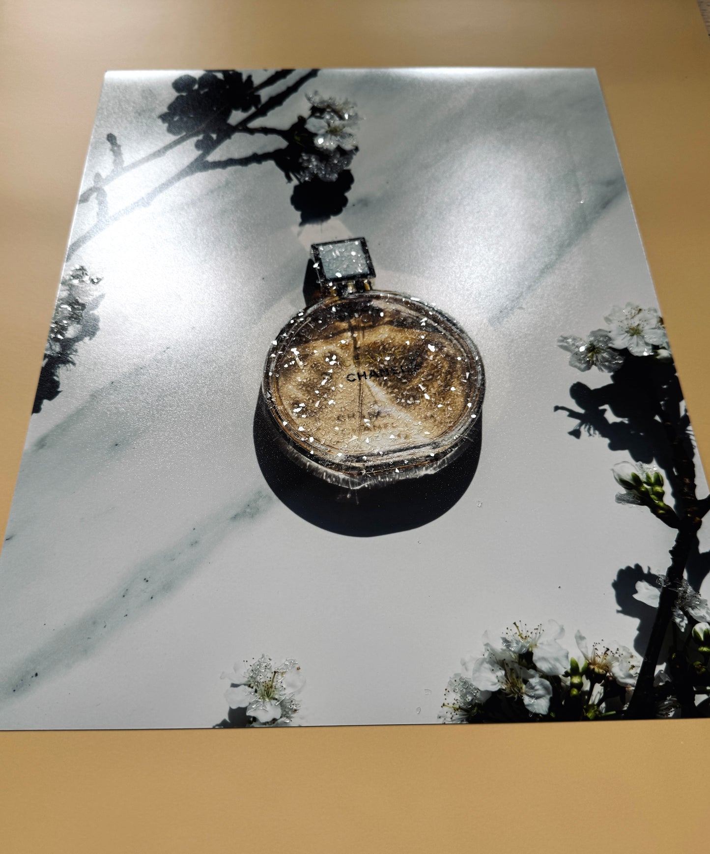 A photo print with sparkle embellished Chanel Perfume.