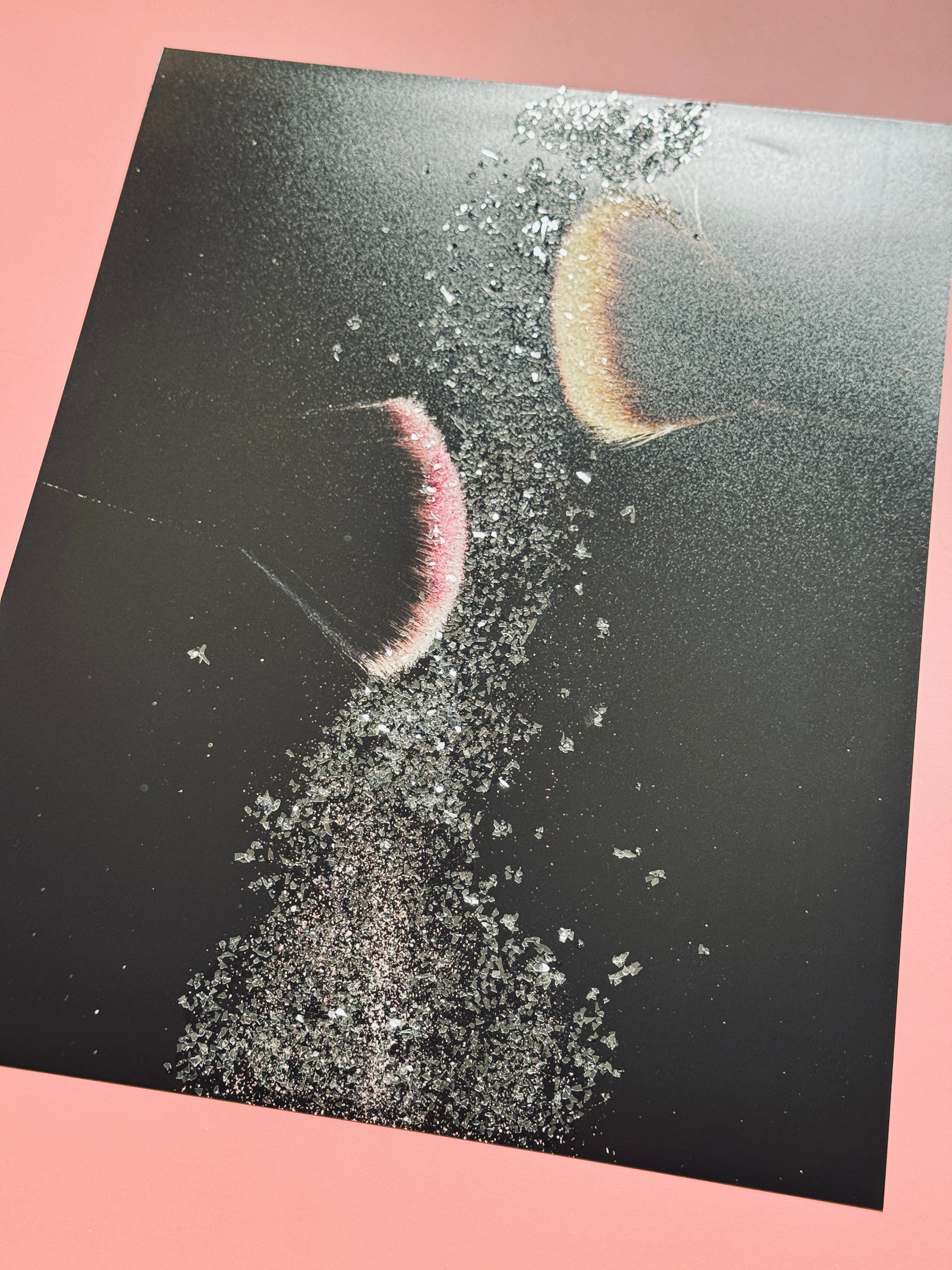 A photograph displaying makeup brushes showered in bedazzled glitter. 