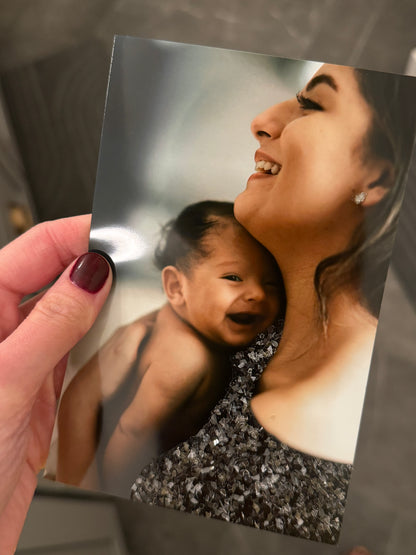 A sample of a photo print of a mom embracing a baby, both smiling and mom's outfit sparkle bedazzled. 
