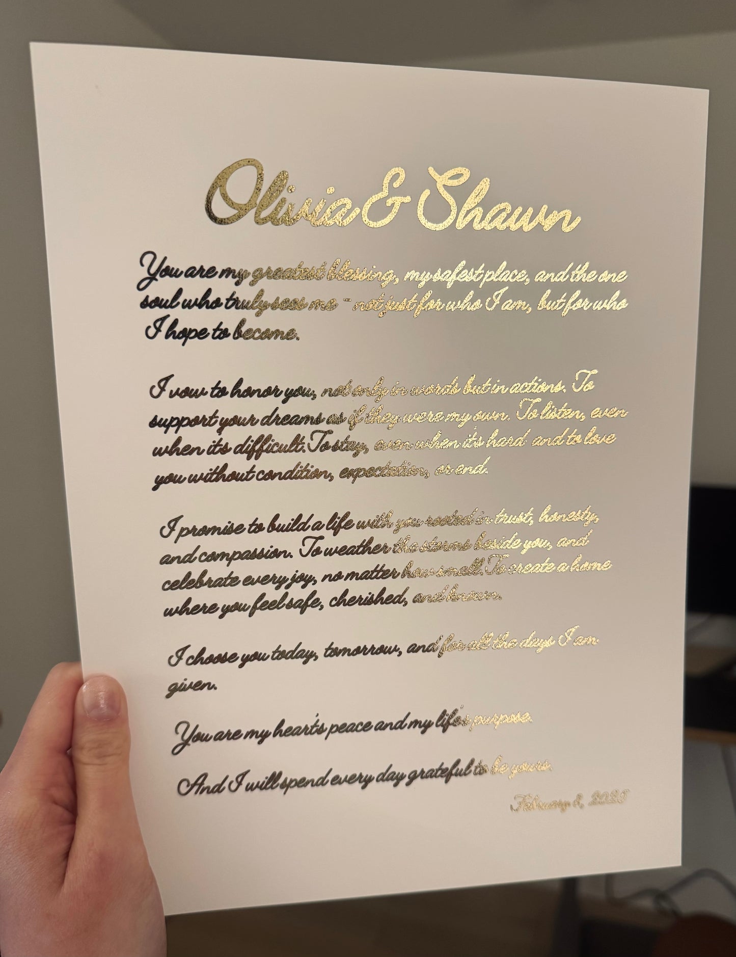 A sample of vows printed in gold foil for Olivia and Shawn on white paper. 