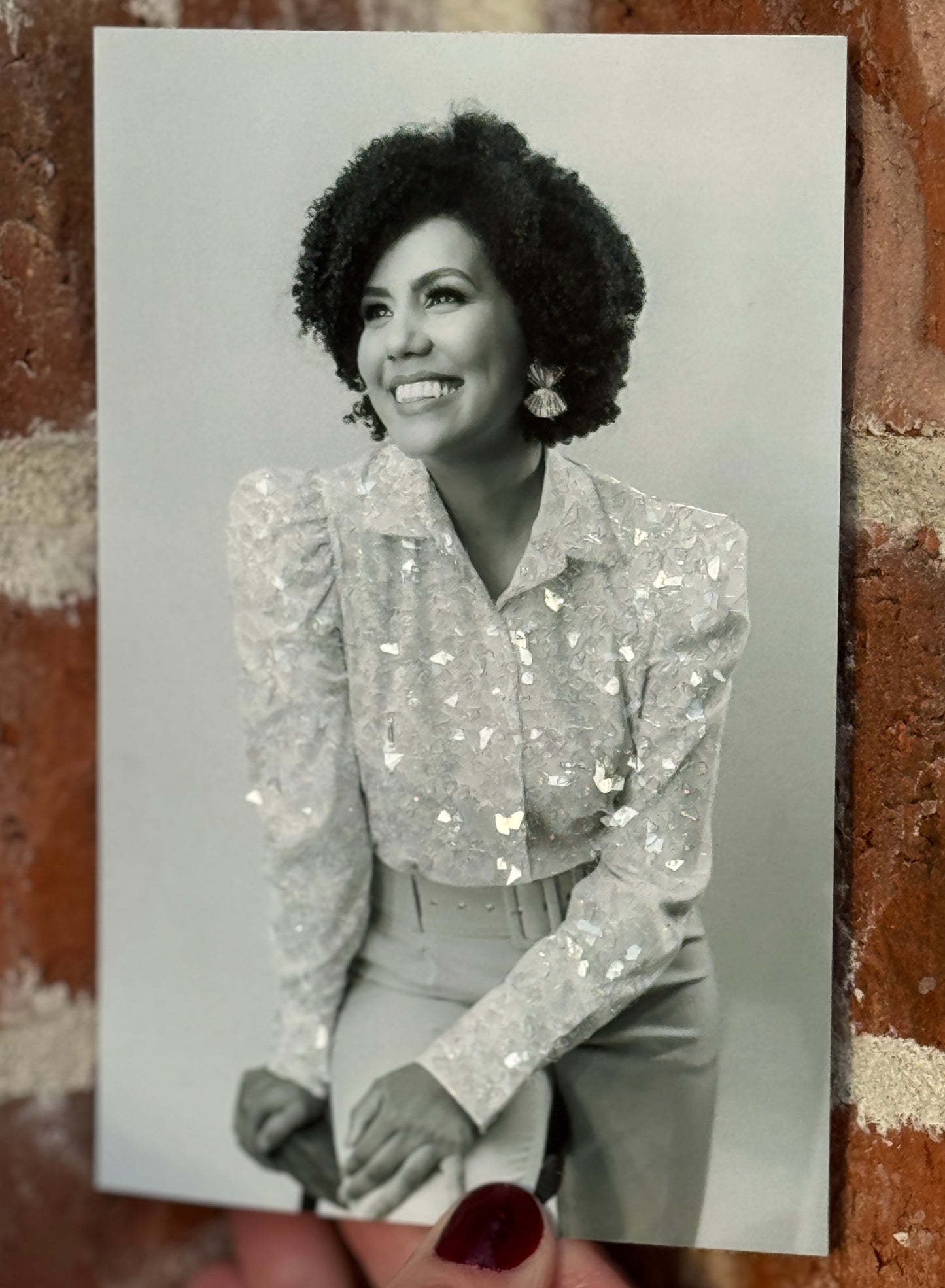 A sample photo print of a professionally dressed, smiling woman with sparkle embellished blouse. 